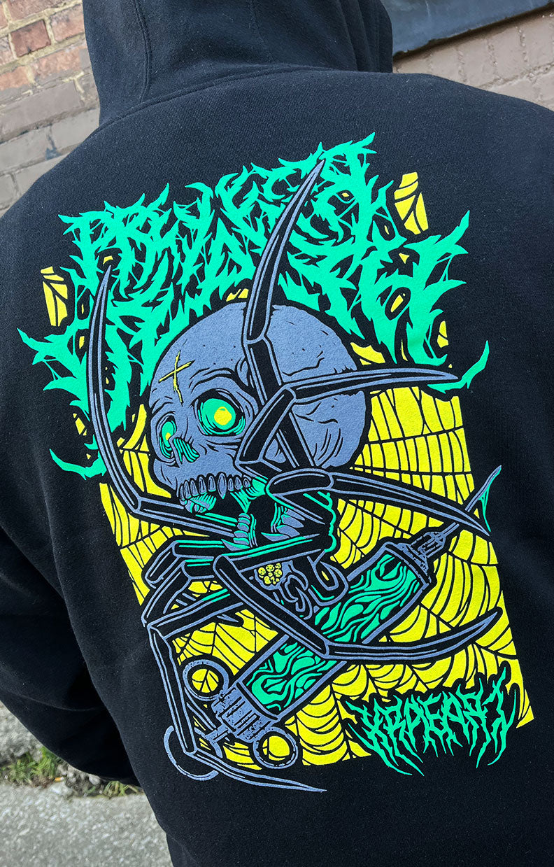 Metal band tee style, Spider hoodie holding needle in green and yellow web. Tattoo inspired Dark Art for mental health by Xraeart Clothing alternative streetwear.